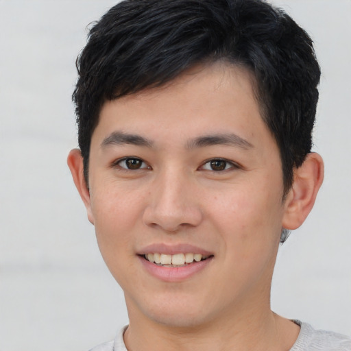 Joyful asian young-adult male with short  brown hair and brown eyes