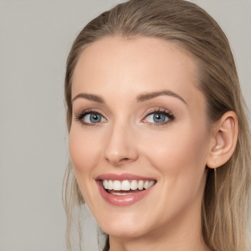 Joyful white young-adult female with long  brown hair and blue eyes