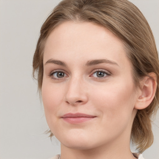 Joyful white young-adult female with medium  brown hair and blue eyes