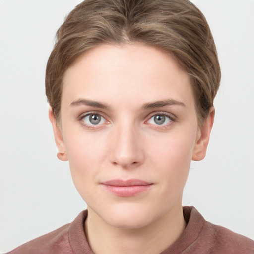 Joyful white young-adult female with short  brown hair and grey eyes