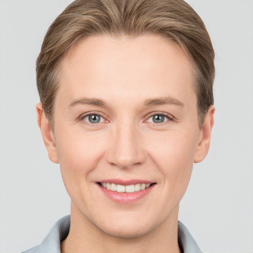 Joyful white young-adult female with short  brown hair and grey eyes