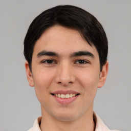 Joyful white young-adult male with short  black hair and brown eyes