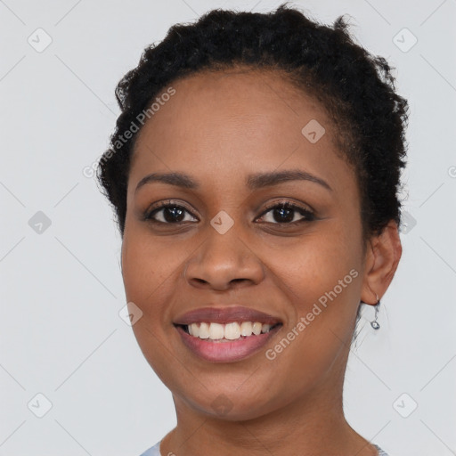 Joyful black young-adult female with short  brown hair and brown eyes