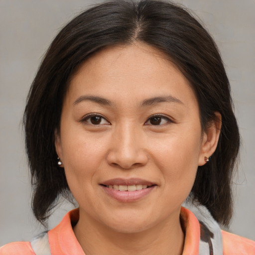 Joyful asian young-adult female with medium  brown hair and brown eyes