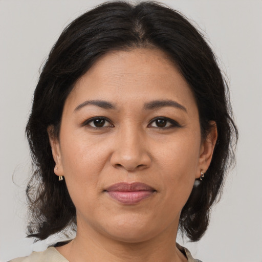 Joyful latino adult female with medium  brown hair and brown eyes