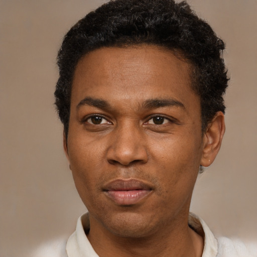 Joyful black young-adult male with short  brown hair and brown eyes