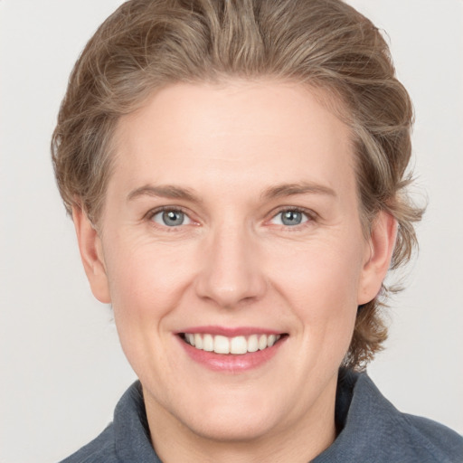 Joyful white adult female with medium  brown hair and grey eyes