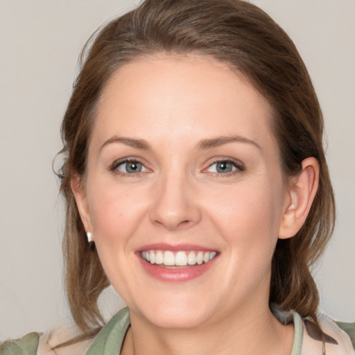 Joyful white young-adult female with medium  brown hair and grey eyes