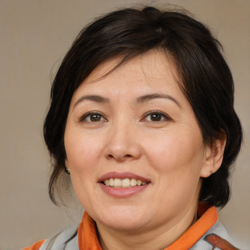Joyful white adult female with medium  brown hair and brown eyes