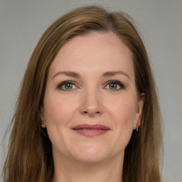 Joyful white young-adult female with long  brown hair and grey eyes