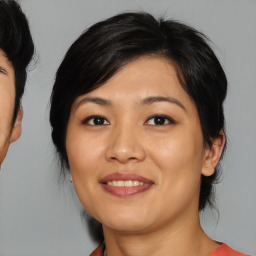 Joyful asian young-adult female with medium  brown hair and brown eyes