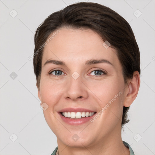 Joyful white young-adult female with short  brown hair and grey eyes