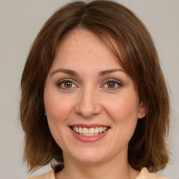 Joyful white young-adult female with medium  brown hair and green eyes