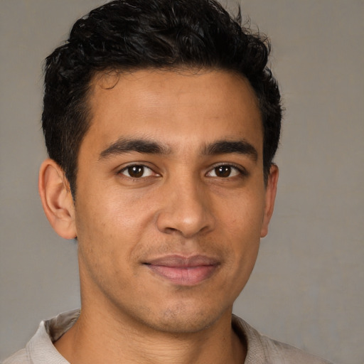Joyful latino young-adult male with short  brown hair and brown eyes