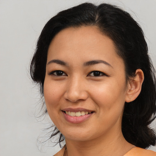 Joyful latino young-adult female with medium  black hair and brown eyes