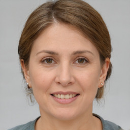 Joyful white adult female with medium  brown hair and grey eyes