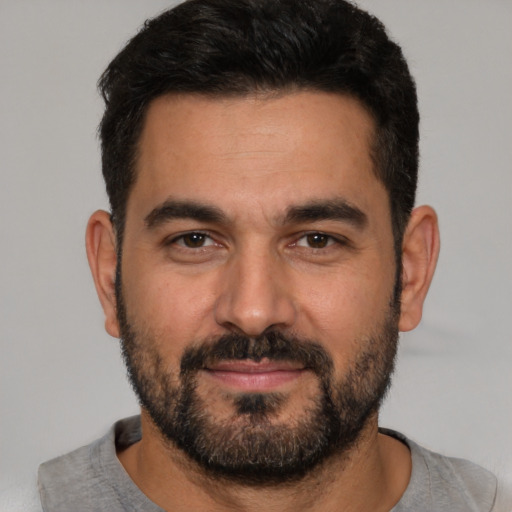 Joyful white young-adult male with short  black hair and brown eyes