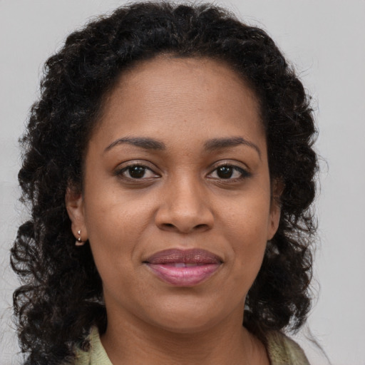 Joyful black adult female with long  brown hair and brown eyes