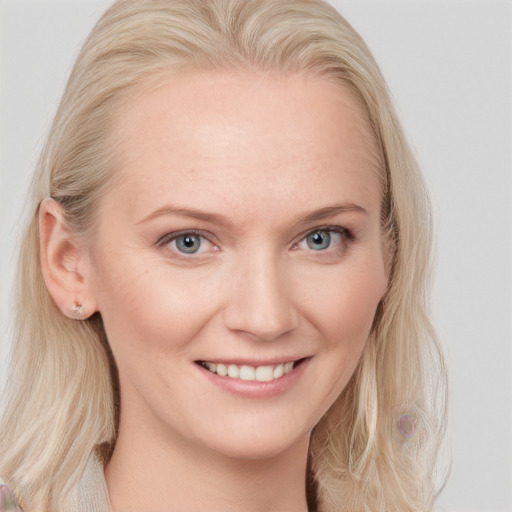 Joyful white young-adult female with long  blond hair and blue eyes