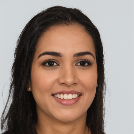 Joyful latino young-adult female with long  brown hair and brown eyes