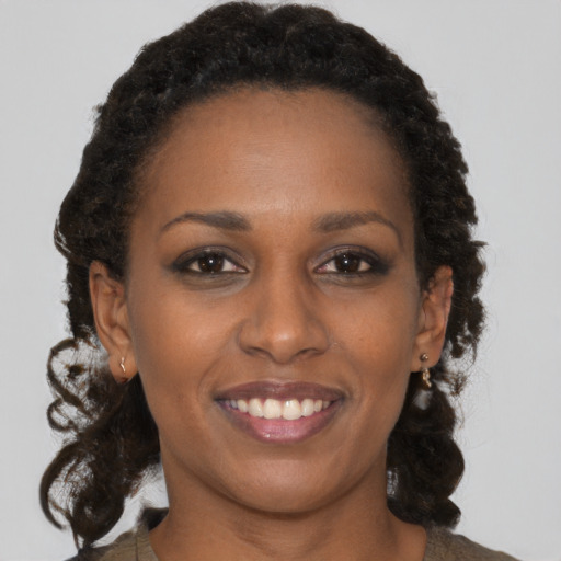 Joyful black young-adult female with medium  brown hair and brown eyes