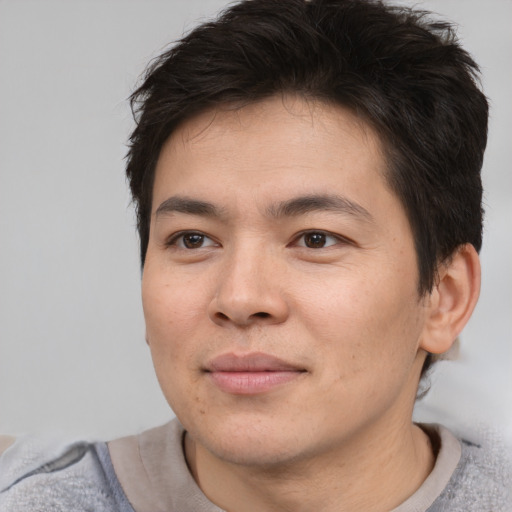 Joyful asian young-adult male with short  brown hair and brown eyes