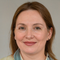 Joyful white adult female with medium  brown hair and blue eyes