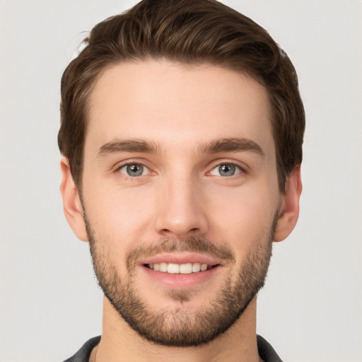 Joyful white young-adult male with short  brown hair and grey eyes