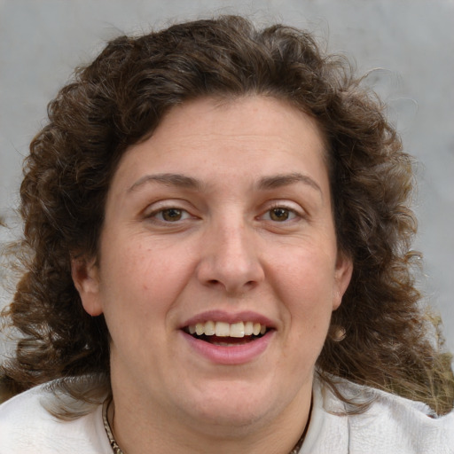 Joyful white adult female with medium  brown hair and blue eyes