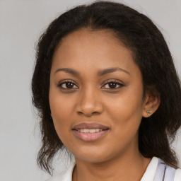 Joyful black young-adult female with long  brown hair and brown eyes