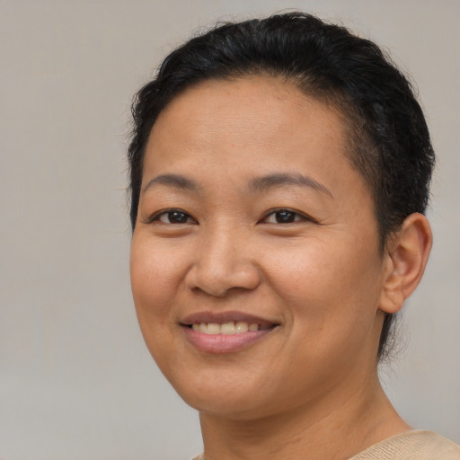 Joyful asian adult female with short  brown hair and brown eyes