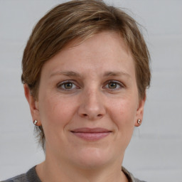 Joyful white adult female with medium  brown hair and grey eyes