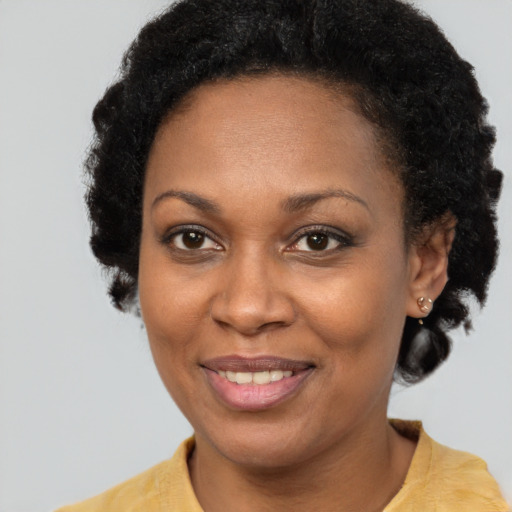 Joyful black adult female with short  brown hair and brown eyes