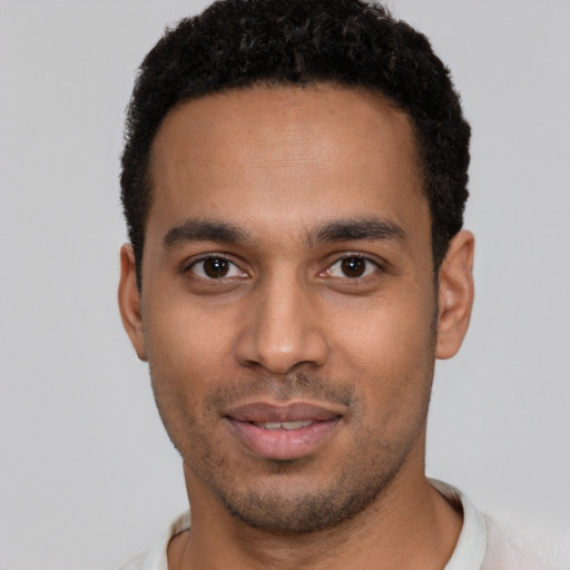 Joyful black young-adult male with short  brown hair and brown eyes