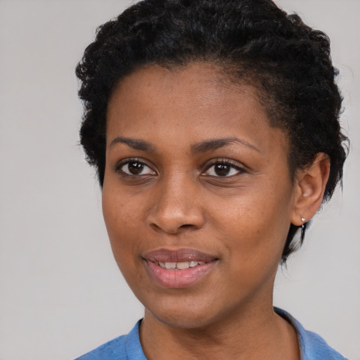 Joyful black young-adult female with short  brown hair and brown eyes
