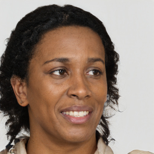 Joyful black adult female with long  brown hair and brown eyes