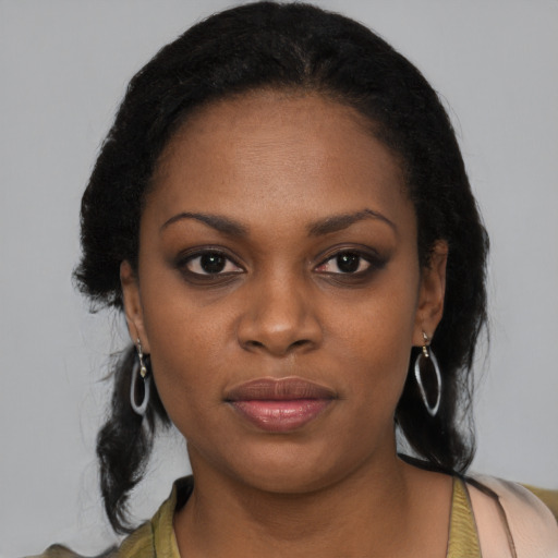 Joyful black young-adult female with long  black hair and brown eyes