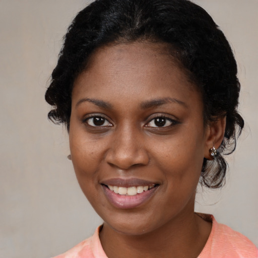 Joyful black young-adult female with medium  brown hair and brown eyes