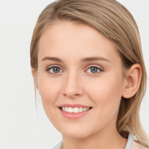 Joyful white young-adult female with long  brown hair and blue eyes