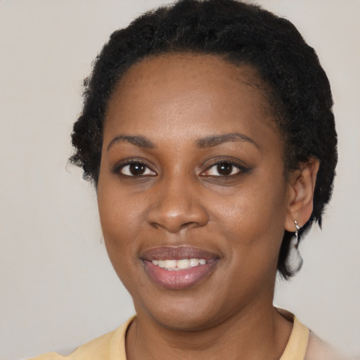 Joyful black young-adult female with short  brown hair and brown eyes