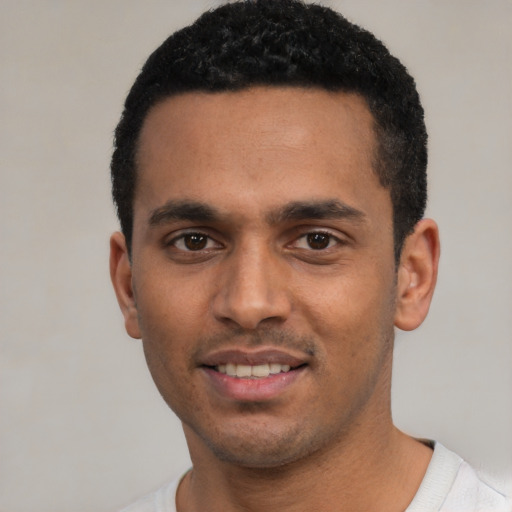Joyful latino young-adult male with short  black hair and brown eyes