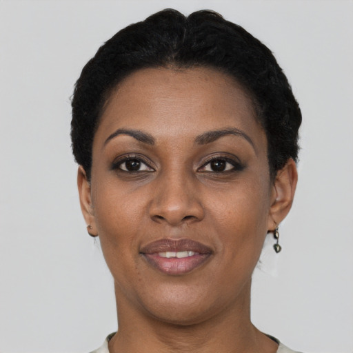 Joyful black young-adult female with short  black hair and brown eyes
