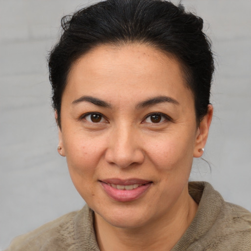 Joyful latino adult female with short  brown hair and brown eyes