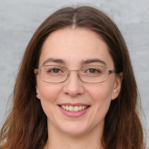 Joyful white adult female with long  brown hair and grey eyes