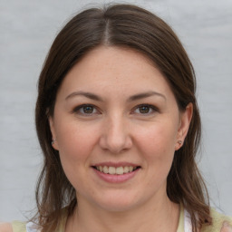 Joyful white young-adult female with medium  brown hair and grey eyes