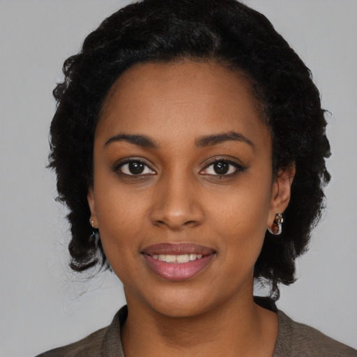 Joyful black young-adult female with long  black hair and brown eyes