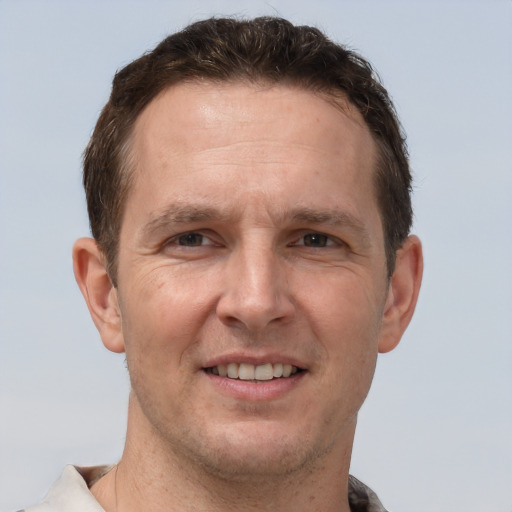 Joyful white adult male with short  brown hair and brown eyes