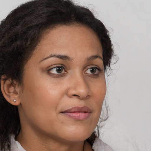 Joyful latino adult female with medium  brown hair and brown eyes