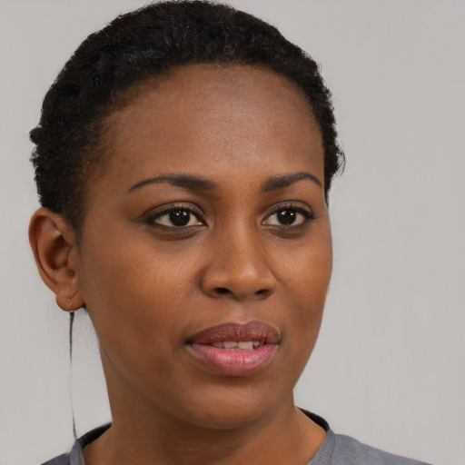 Joyful black young-adult female with short  brown hair and brown eyes