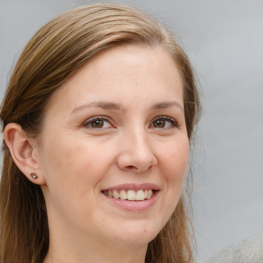 Joyful white adult female with long  brown hair and grey eyes